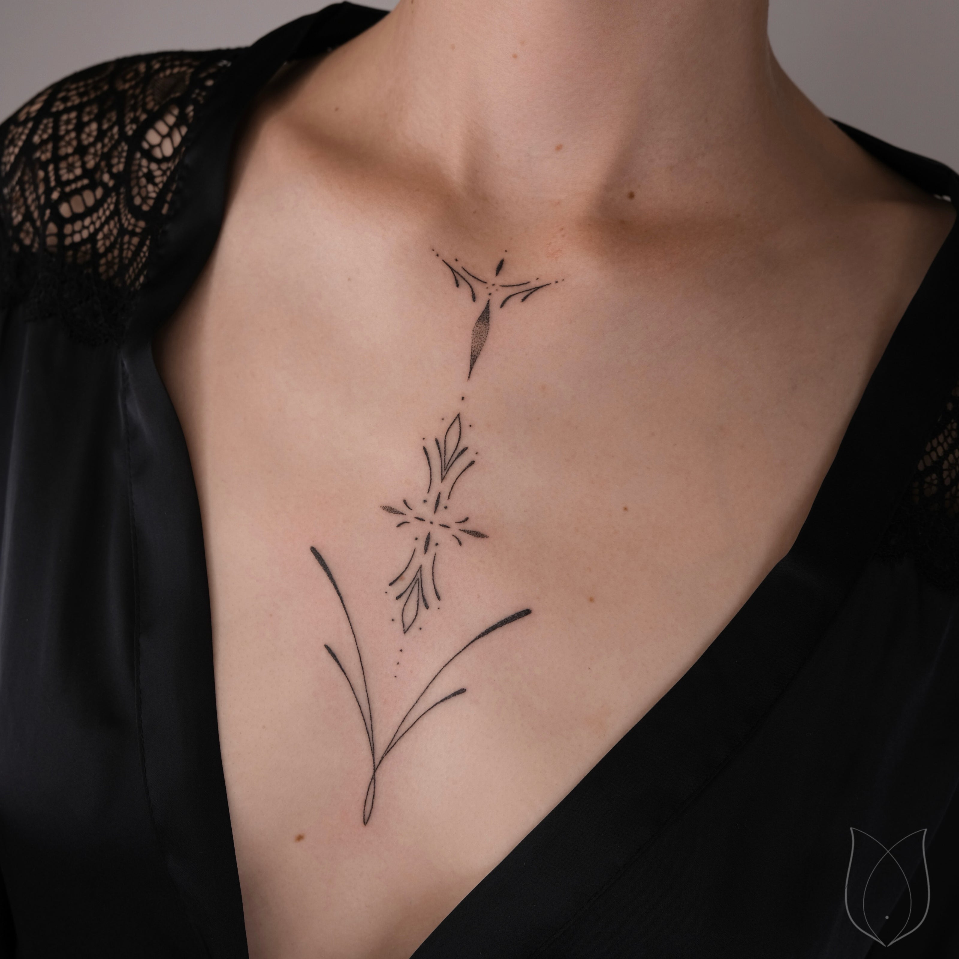 handpoke Finline Ornament Tattoo im Dekolleté