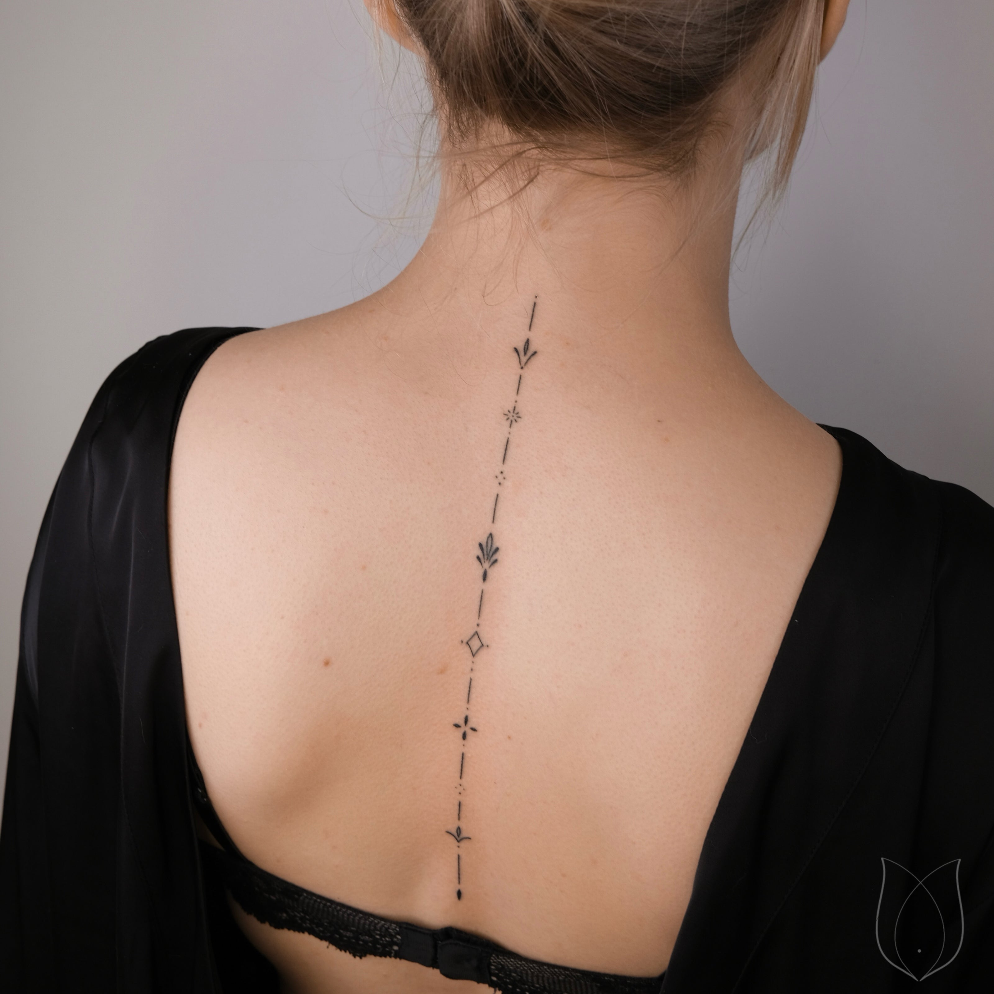 Kleine Symbole handpoke Tattoo auf der Wirbelsäule Rücken
